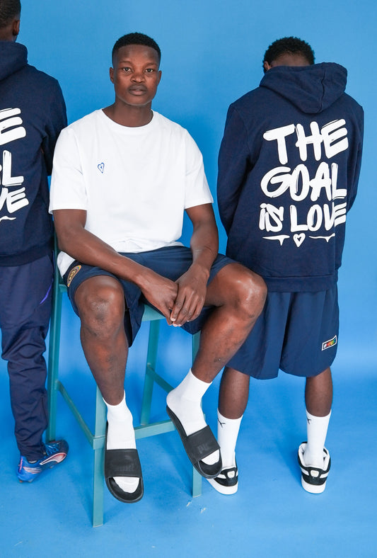 Three people wearing navy hoodies with 'The Goal Is Love' text on a blue background